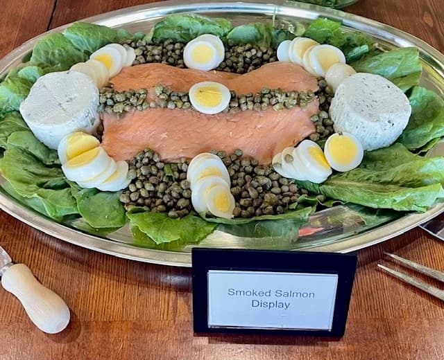 A smoked-salmon display with lettuce, sliced eggs, capers, and cheese.
