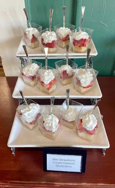Mini strawberry cream-cheese shortcakes on white tiered serving stands.