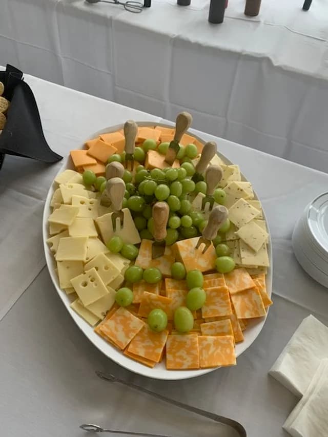 A cheese and green-grape platter with toothpicks and napkins.
